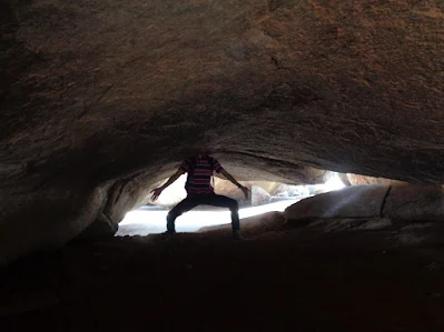hiker pretending to be a headless chicken in dark caves at the summit of nijagal betta